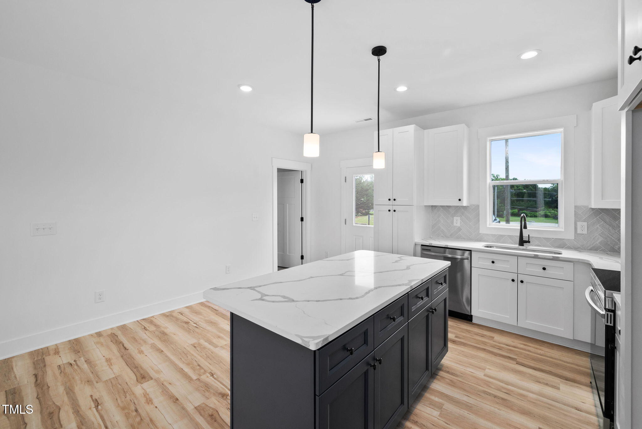 50 Southern Village Drive Roxboro, NC 27573 - Photo 13 of 32 a kitchen with a stove sink and white cabinets