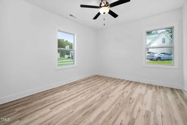 a view of a room with wooden floor and white walls