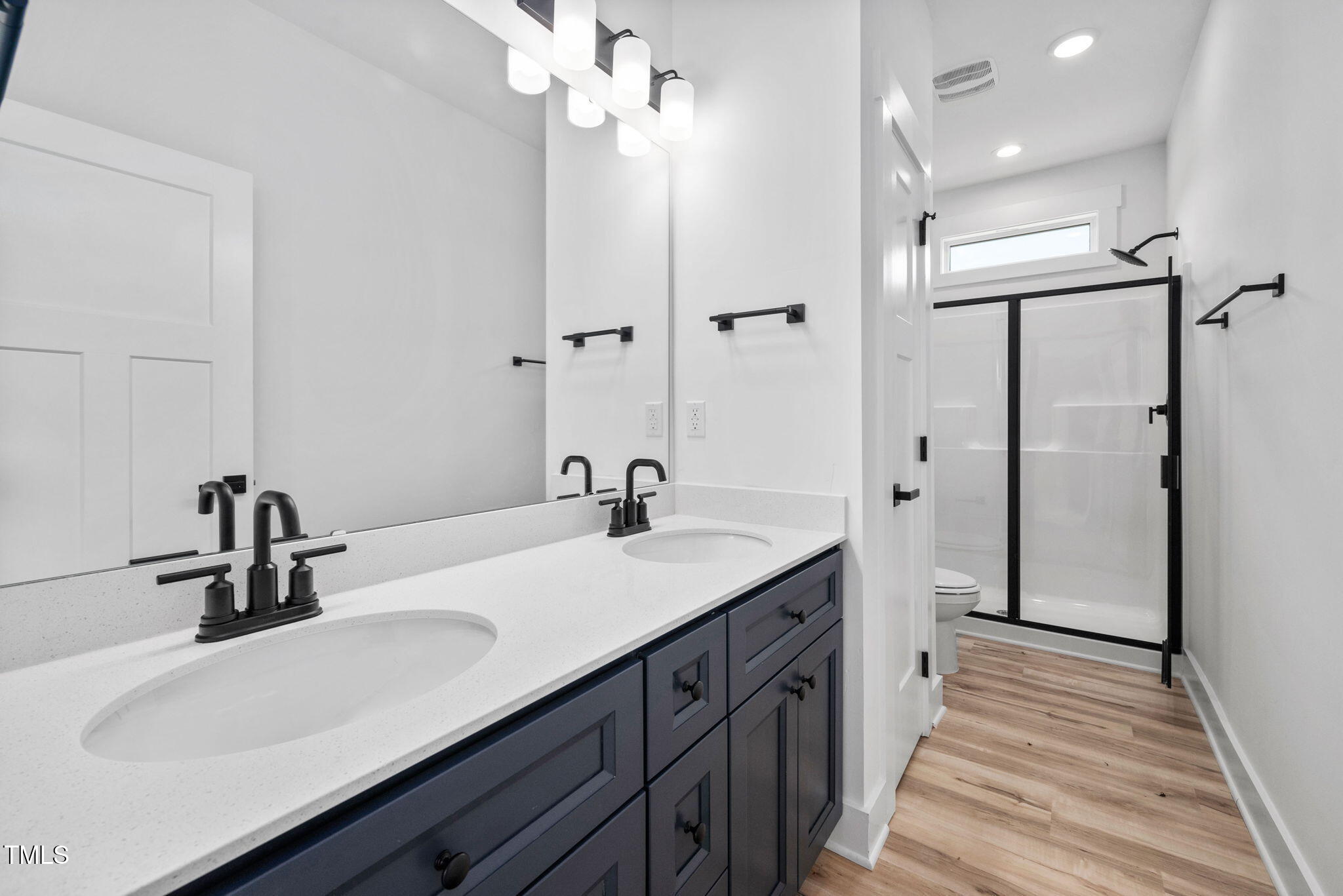 50 Southern Village Drive Roxboro, NC 27573 - Photo 23 of 32 a bathroom with a double vanity sink a mirror and shower