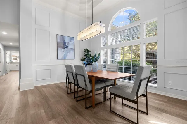 a large white kitchen with kitchen island a sink table and chairs
