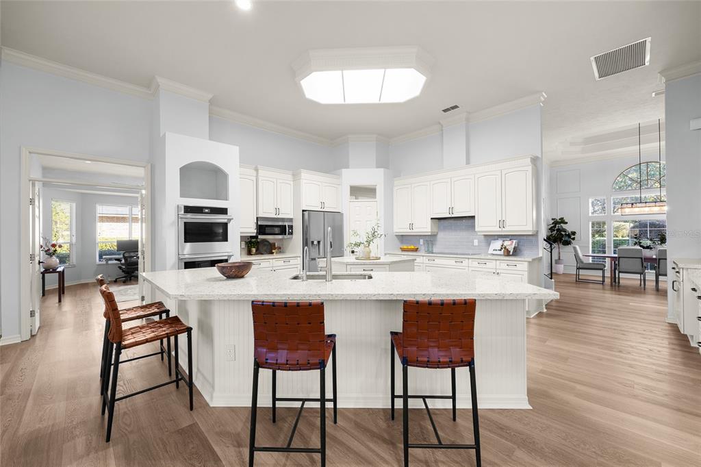 4606 Southwest 97th Terrace Gainesville, FL 32608 - Photo 20 of 68 a kitchen with stainless steel appliances kitchen island granite countertop a dining table chairs and view living room