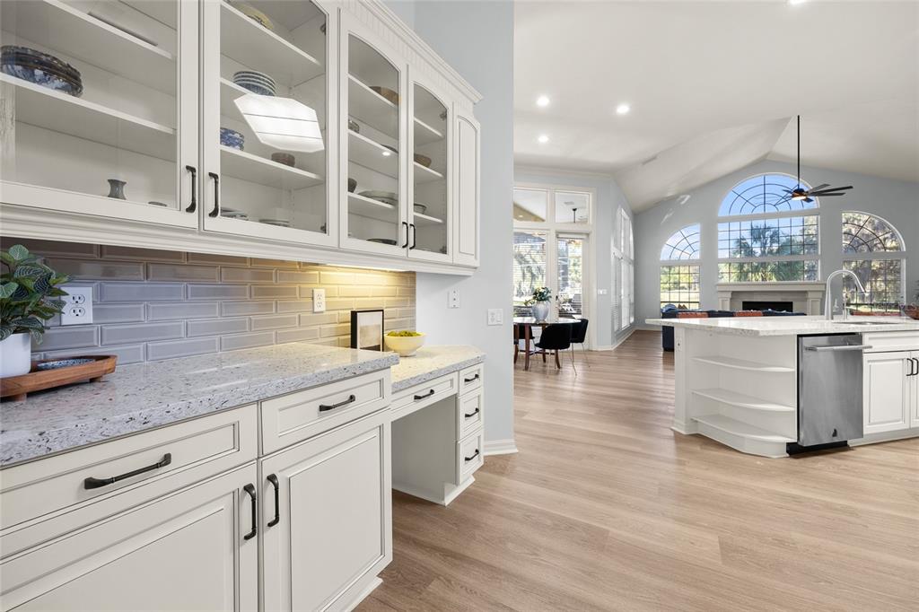 4606 Southwest 97th Terrace Gainesville, FL 32608 - Photo 21 of 68 a kitchen with stainless steel appliances granite countertop a sink dishwasher a refrigerator and white cabinets with wooden floor