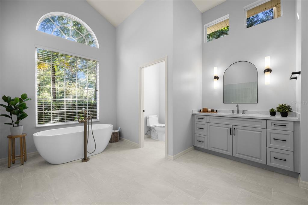 4606 Southwest 97th Terrace Gainesville, FL 32608 - Photo 32 of 68 a spacious bathroom with a double vanity sink a large mirror a bathtub and window
