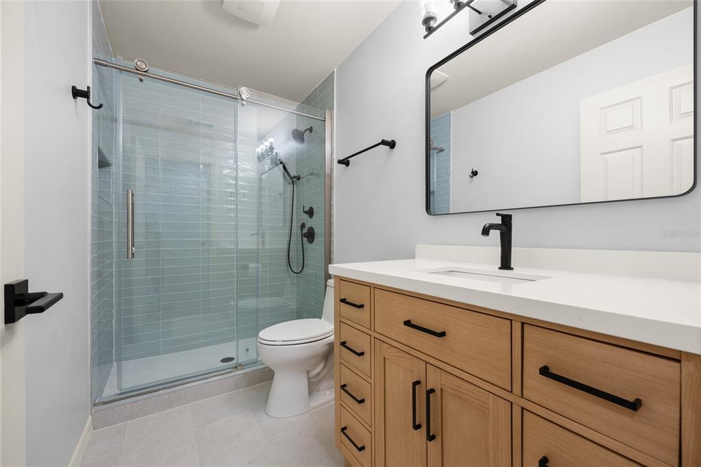 4606 Southwest 97th Terrace Gainesville, FL 32608 - Photo 34 of 68 a bathroom with a shower sink vanity mirror and toilet