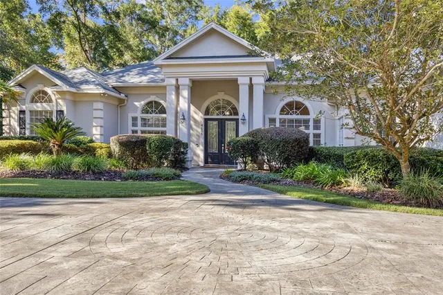 a front view of a house with a yard and potted plants