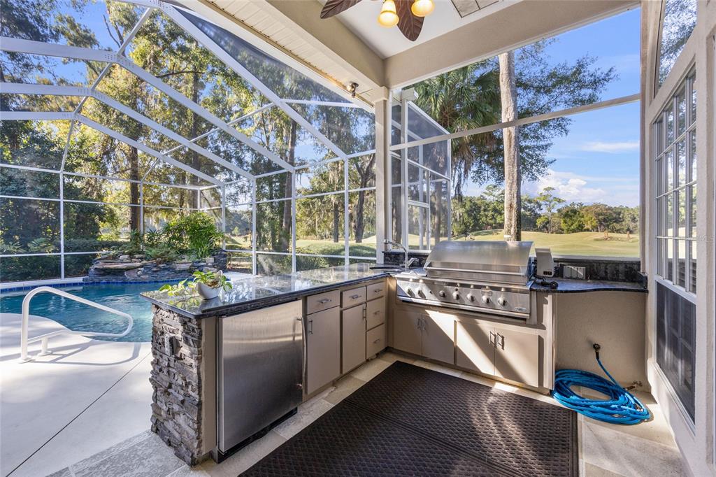 4606 Southwest 97th Terrace Gainesville, FL 32608 - Photo 48 of 68 a kitchen with stainless steel appliances granite countertop a sink and wooden cabinets