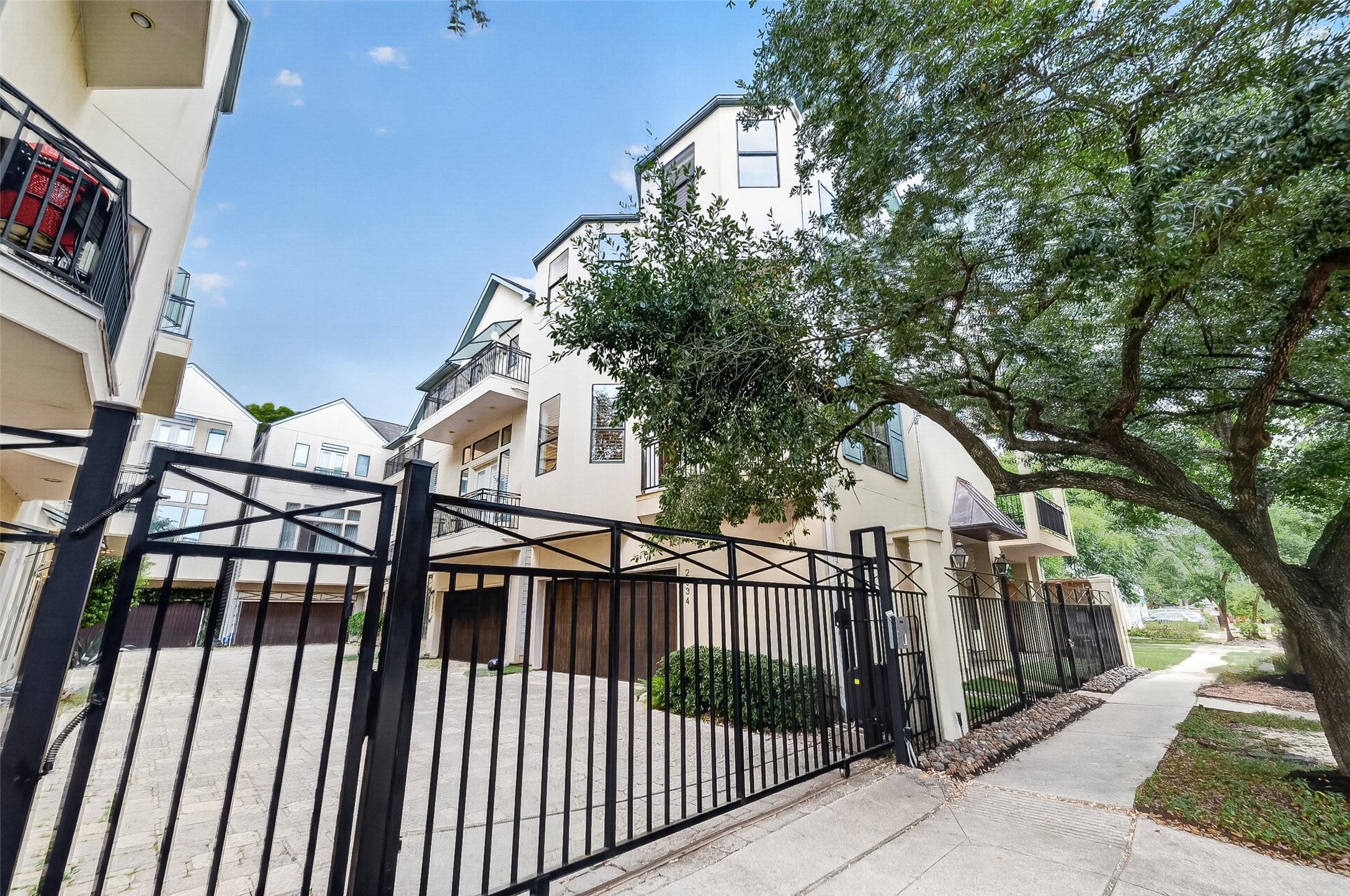 2034 Colquitt Street, Unit A Houston, TX 77098 - Photo 7 of 41 Classic multi-story townhouse with gated entrance, offering secure access and privacy. The building features balconies and large windows, with a well-maintained exterior. A tree-lined sidewalk adds a charming touch to the urban setting. Only 8 units!