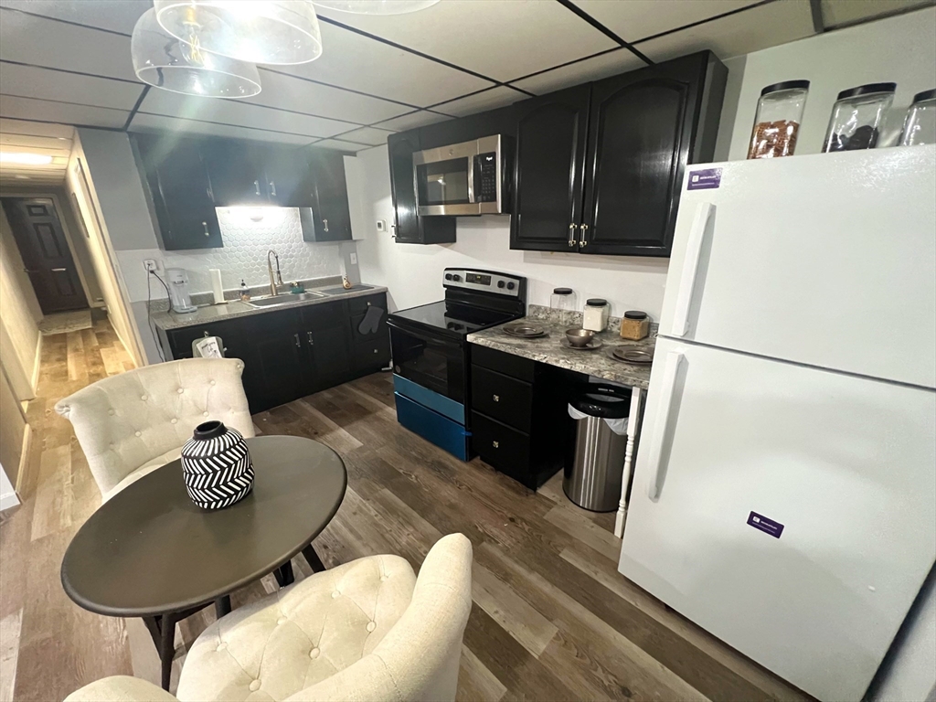 904 Main, Unit A Winchester, MA 01890 - Photo 3 of 6 a kitchen with stainless steel appliances granite countertop a sink stove and refrigerator