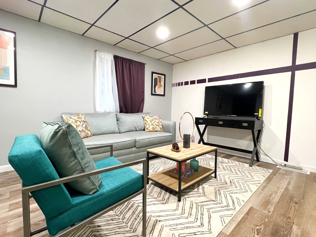 904 Main, Unit A Winchester, MA 01890 - Photo 4 of 6 a living room with furniture and a flat screen tv
