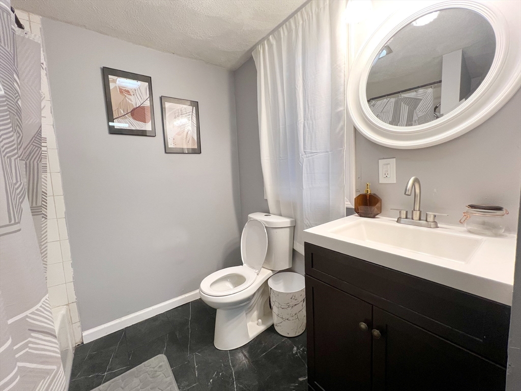 904 Main, Unit A Winchester, MA 01890 - Photo 6 of 6 a bathroom with a toilet a sink and mirror