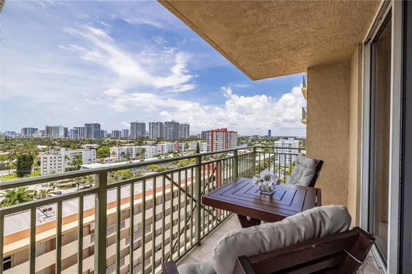a view of a city from a balcony with furniture