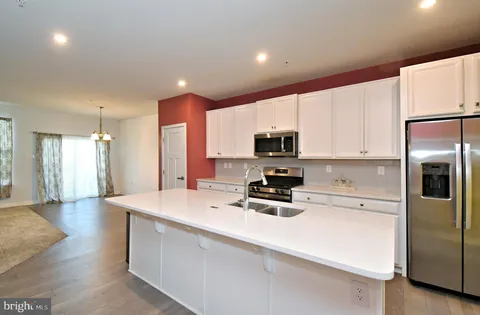 a kitchen with stainless steel appliances a refrigerator sink and microwave