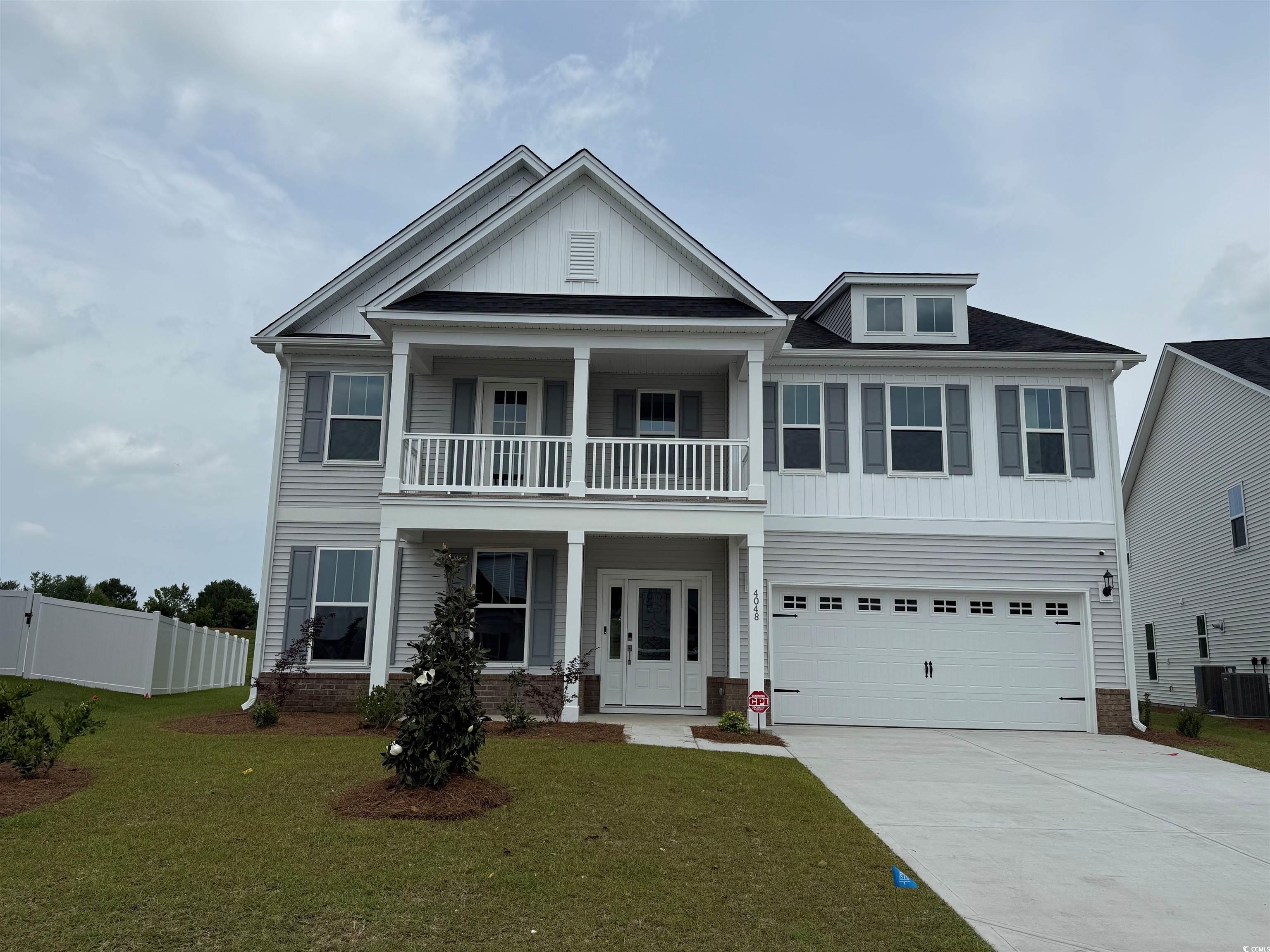 4048 Bucolic Loop Myrtle Beach, SC 29588 - Photo 1 of 13 View of front of property with a balcony, driveway, central air condition unit, an attached garage, and a porch