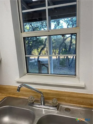 an empty room with wooden floor and a ceiling fan