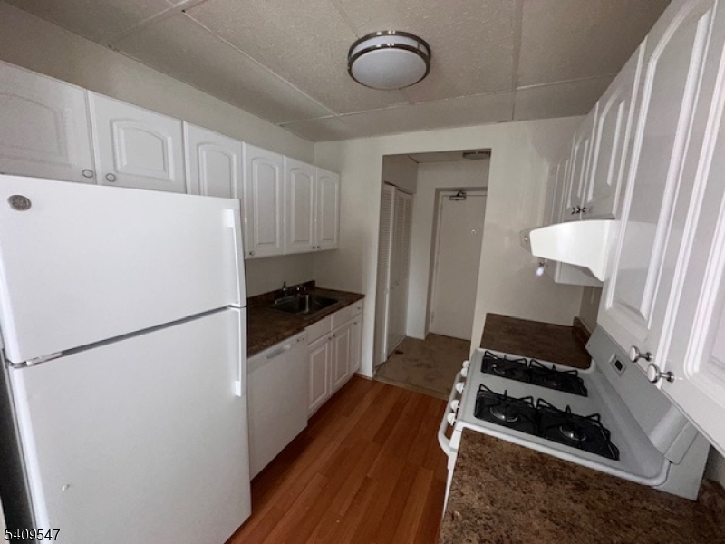 77 Prospect Avenue, Unit A Hackensack, NJ 07601 - Photo 4 of 16 a kitchen with sink refrigerator and stove