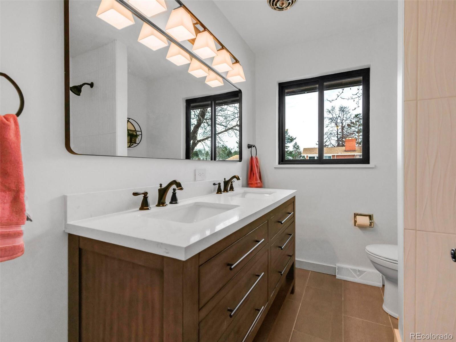 1345 Overhill Road Golden, CO 80401 - Photo 14 of 40 a bathroom with a granite countertop sink mirror and toilet