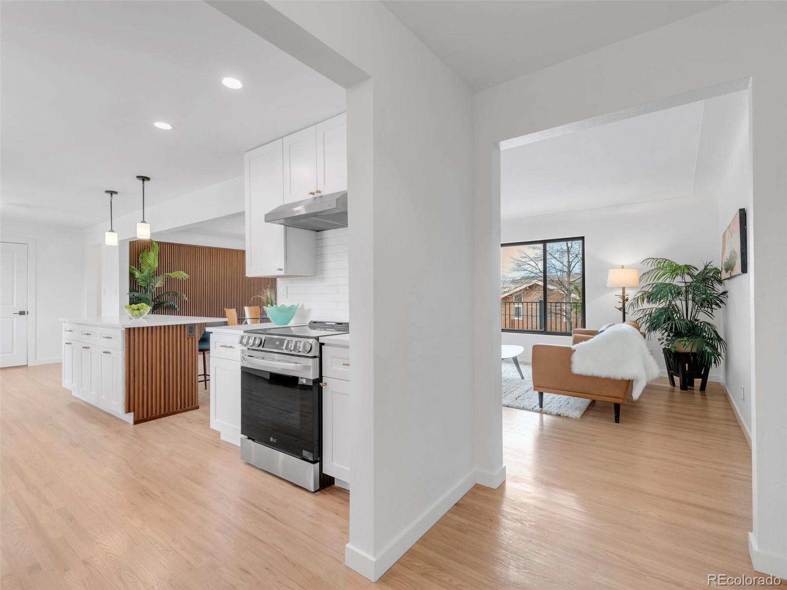 1345 Overhill Road Golden, CO 80401 - Photo 27 of 40 a kitchen with stainless steel appliances kitchen island wooden floors and white walls