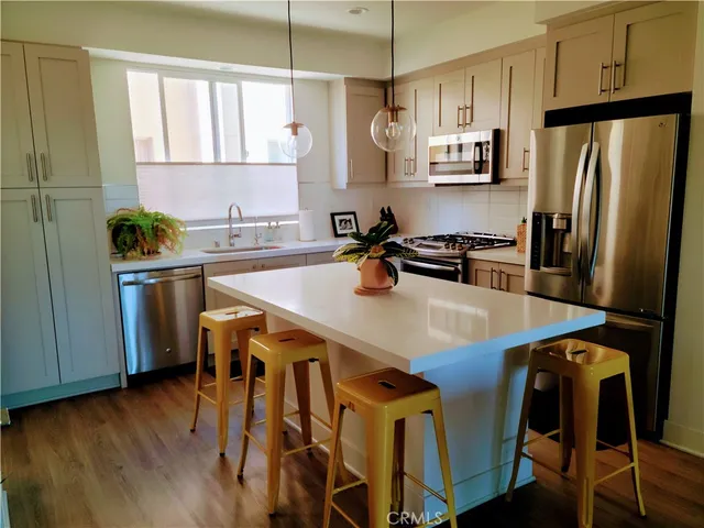 a kitchen with stainless steel appliances a stove a sink a refrigerator and cabinets