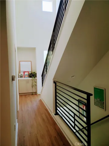 a view of a hallway with wooden floor and staircase