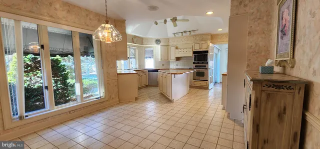 a open kitchen with stainless steel appliances granite countertop a refrigerator and a stove top oven