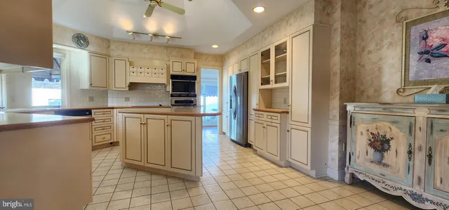 a kitchen with stainless steel appliances granite countertop a refrigerator and a stove top oven
