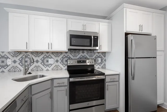 a kitchen with cabinets stainless steel appliances and a sink