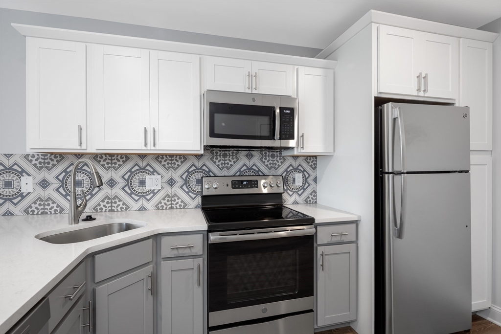 101 California Avenue, Unit 303 Quincy, MA 02169 - Photo 2 of 13 a kitchen with cabinets stainless steel appliances and a sink