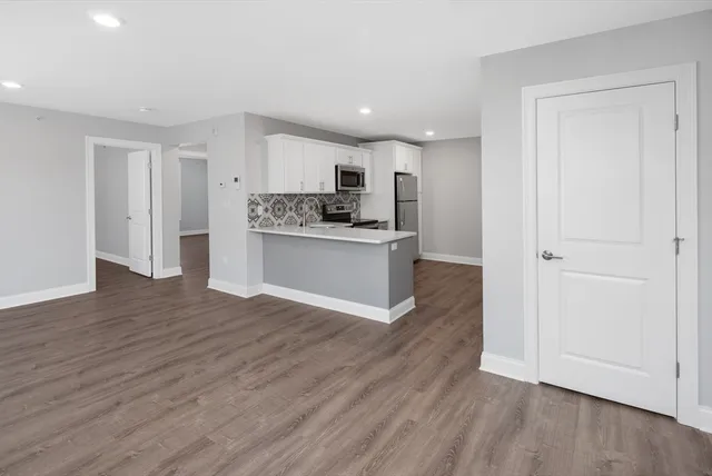 a view of kitchen with stainless steel appliances granite countertop a stove top oven and a refrigerator