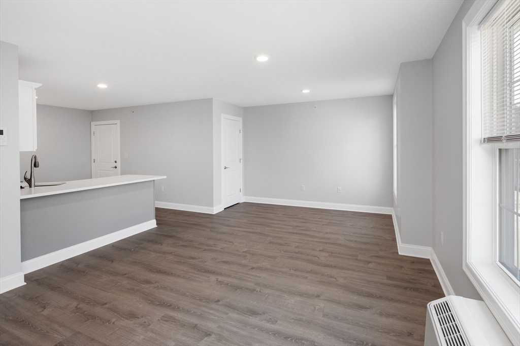 101 California Avenue, Unit 303 Quincy, MA 02169 - Photo 5 of 13 a view of an empty room with wooden floor and a window