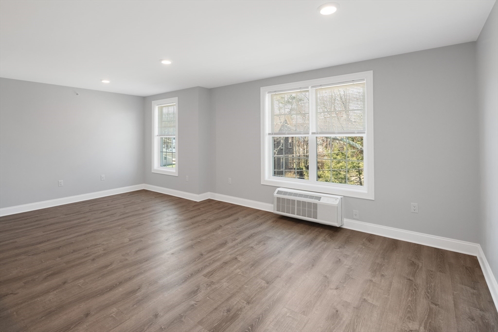 101 California Avenue, Unit 303 Quincy, MA 02169 - Photo 7 of 13 an empty room with wooden floor and windows
