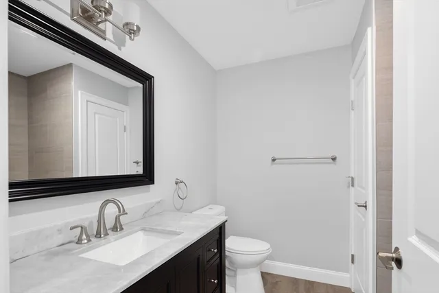 a bathroom with a toilet sink and mirror