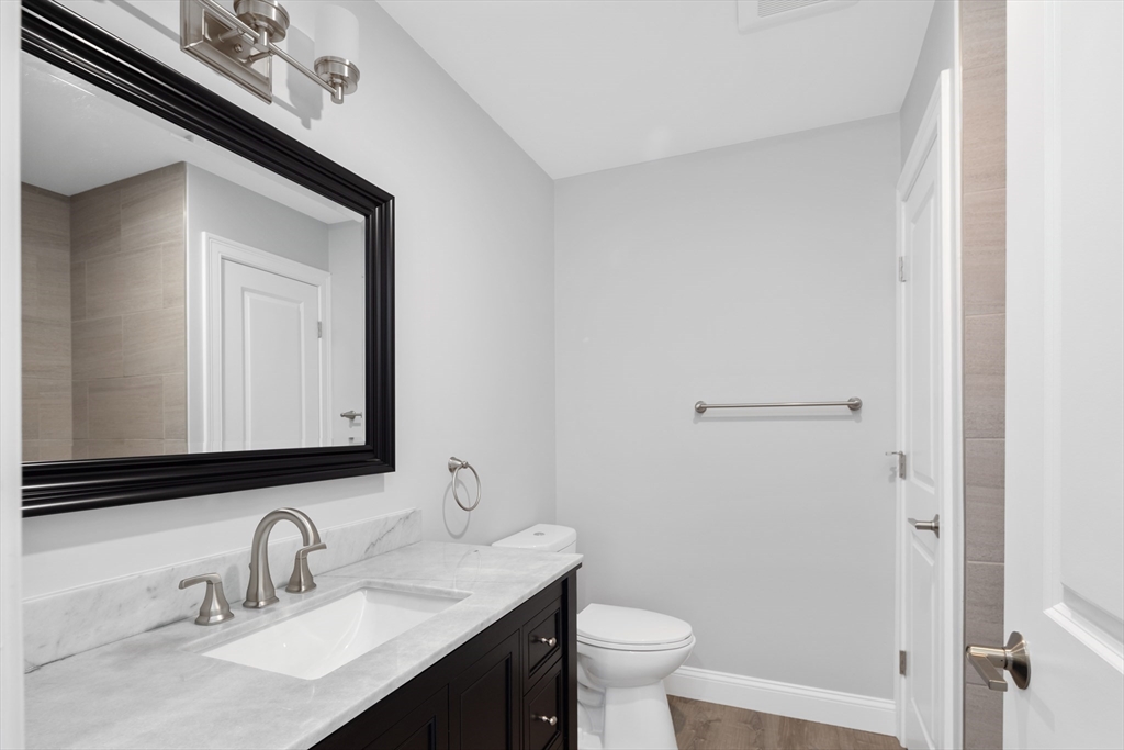 101 California Avenue, Unit 303 Quincy, MA 02169 - Photo 8 of 13 a bathroom with a toilet sink and mirror
