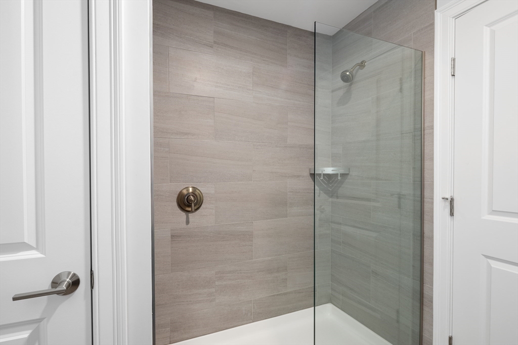 101 California Avenue, Unit 303 Quincy, MA 02169 - Photo 9 of 13 a bathroom with a glass shower door