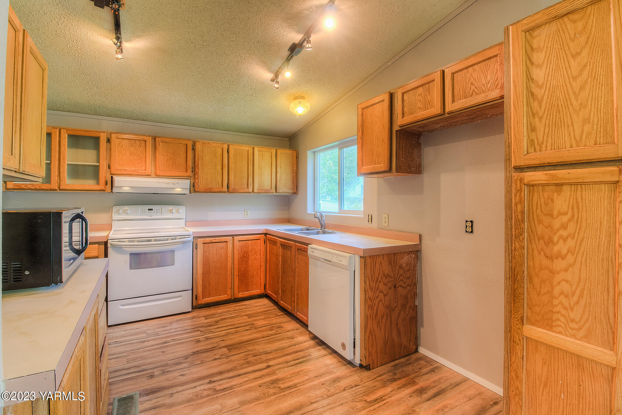 1710 North Fork Road Yakima, WA 98903 - Photo 11 of 34 a kitchen with stainless steel appliances granite countertop a stove a sink dishwasher and a refrigerator with wooden floor