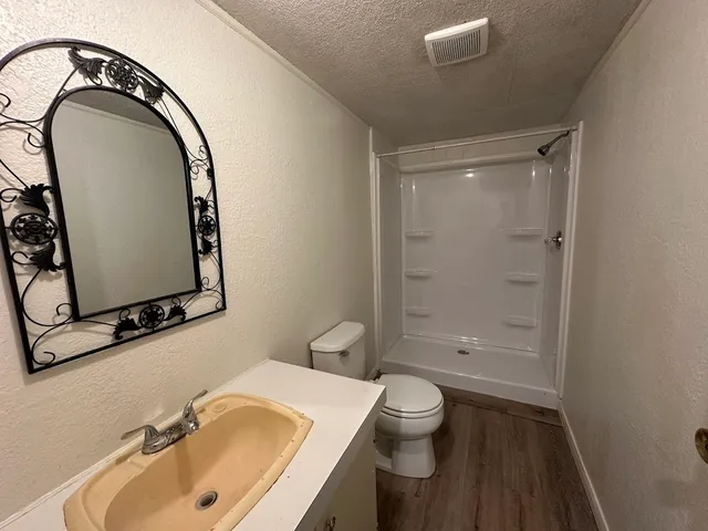 a bathroom with a sink a toilet and a mirror