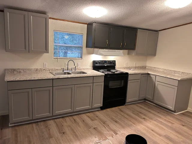 a kitchen with a sink stove and cabinets
