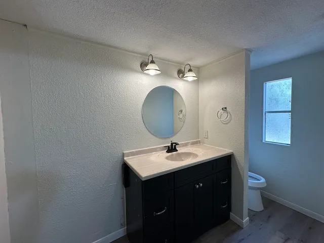 a bathroom with a toilet sink and mirror