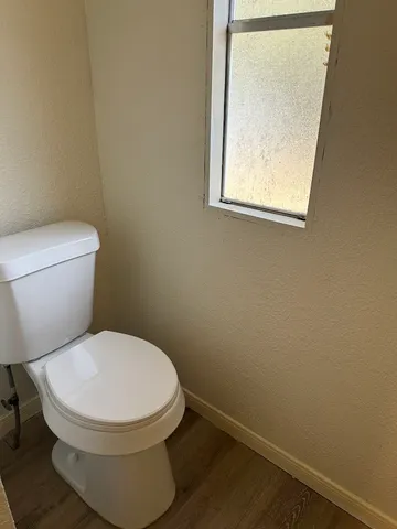 a white toilet sitting next to a small window