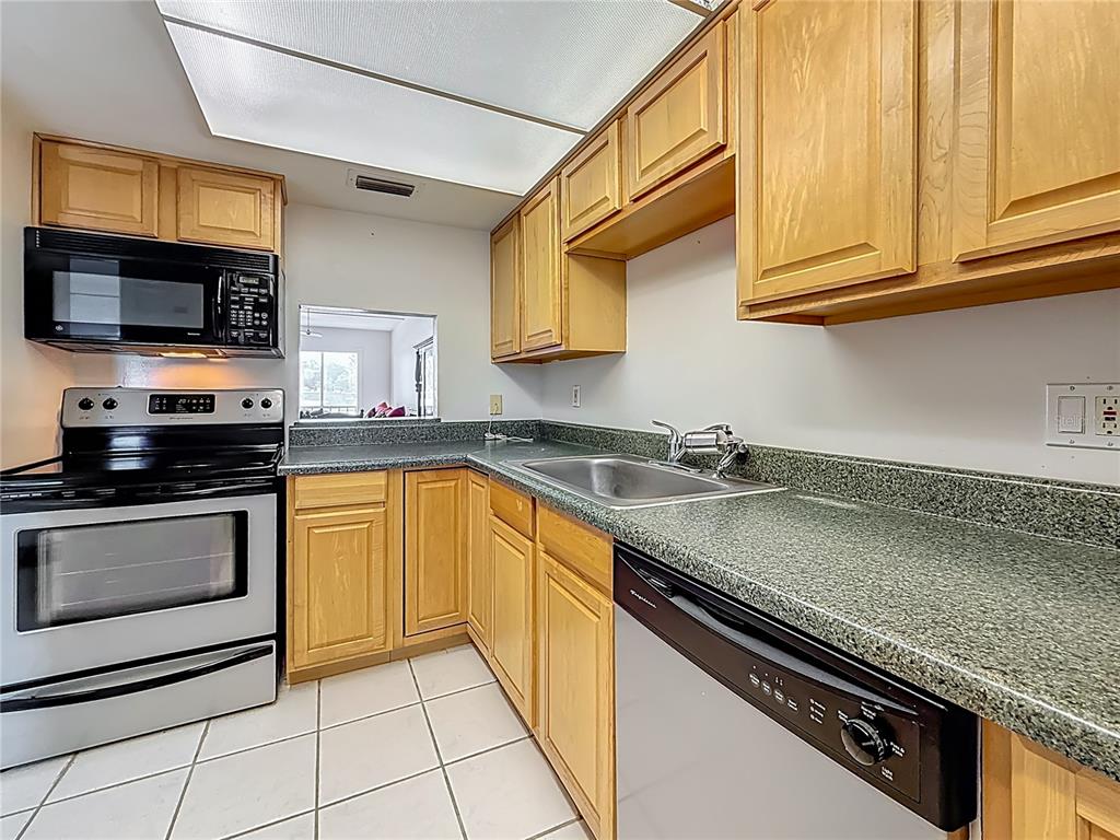 1 Boca Ciega Point Boulevard, Unit 215 St. Petersburg, FL 33708 - Photo 15 of 39 a kitchen with stainless steel appliances granite countertop a sink stove and microwave