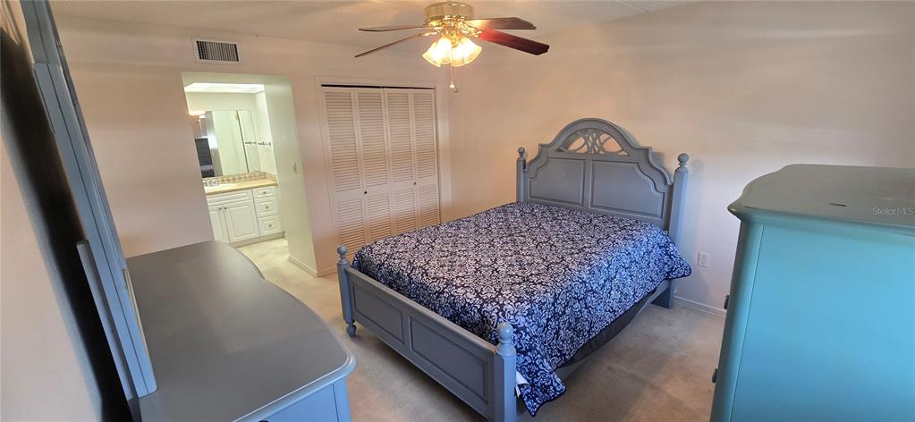 1 Boca Ciega Point Boulevard, Unit 215 St. Petersburg, FL 33708 - Photo 19 of 39 a bedroom with a bed and a chandelier