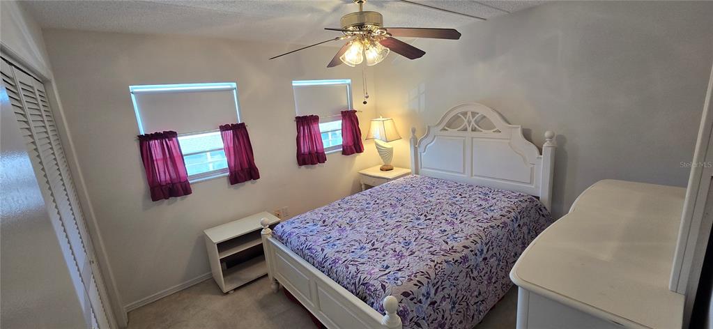 1 Boca Ciega Point Boulevard, Unit 215 St. Petersburg, FL 33708 - Photo 22 of 39 a bedroom with a bed and a chandelier