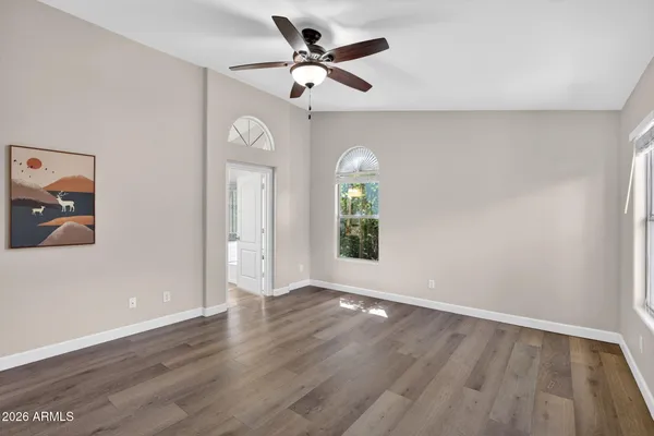 a view of an empty room with a window and wooden floor