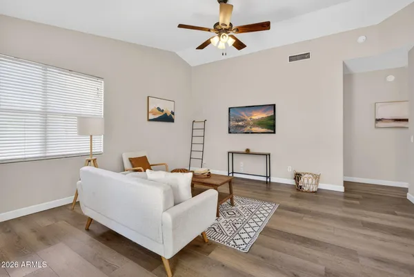 a living room with furniture and a wooden floor