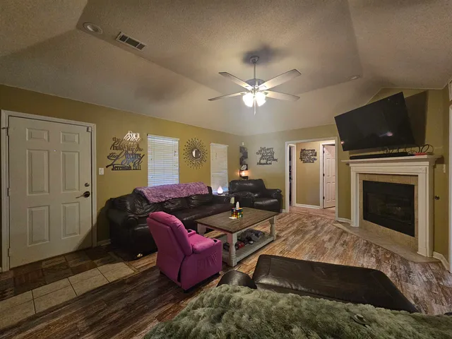 a living room with furniture a flat screen tv and a fireplace