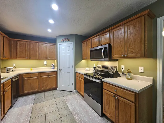 a kitchen with a sink stove top oven and refrigerator