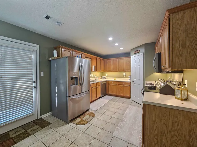 a kitchen with granite countertop a sink stainless steel appliances and cabinets