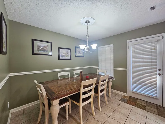 a view of a dining room with furniture and chandelier