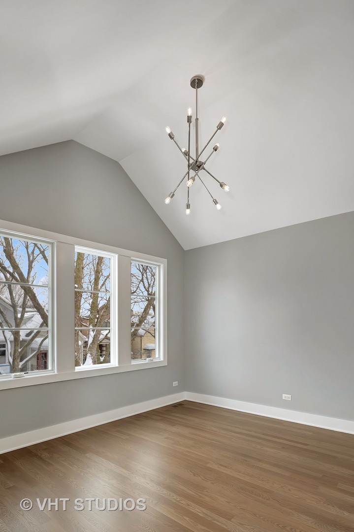 3712 North Marshfield Avenue Chicago, IL 60613 - Photo 17 of 21 an empty room with wooden floor fan and windows