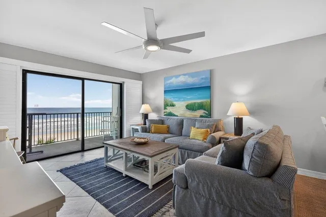 a living room with furniture a flat screen tv and a large window