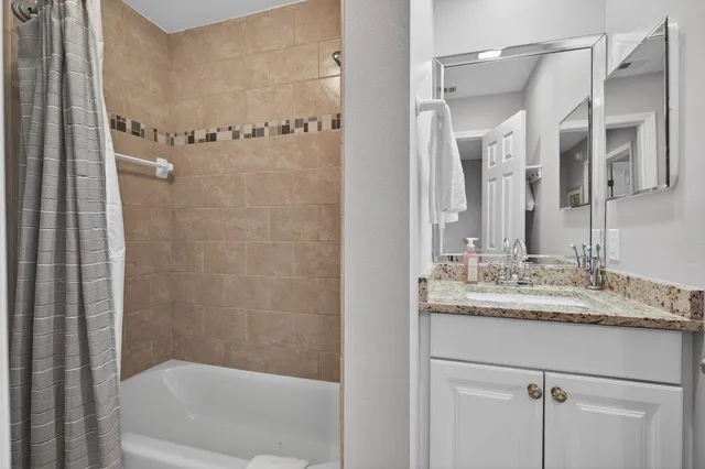 a bathroom with a granite countertop shower a toilet and a sink